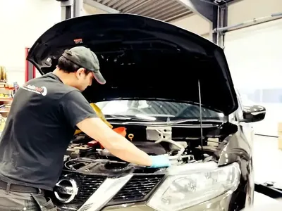 Mekaniker arbetar i motorrummet – Lomma Bilexperten Center